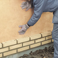 För sedan ner isoleringsskivorna i spalten bakom tegelstenarna