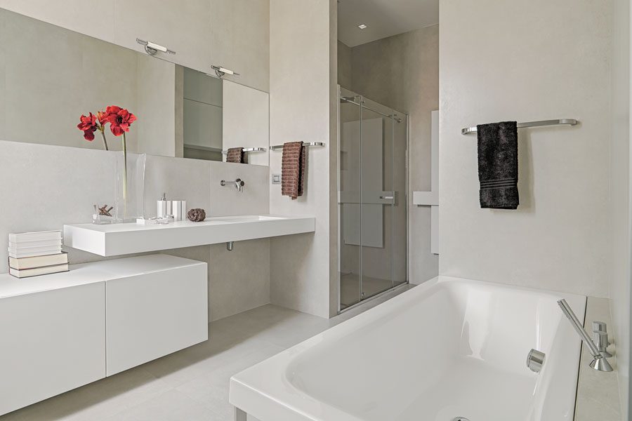 Badrumsinredning med vacker komod, badrumsspegel och duschväggar